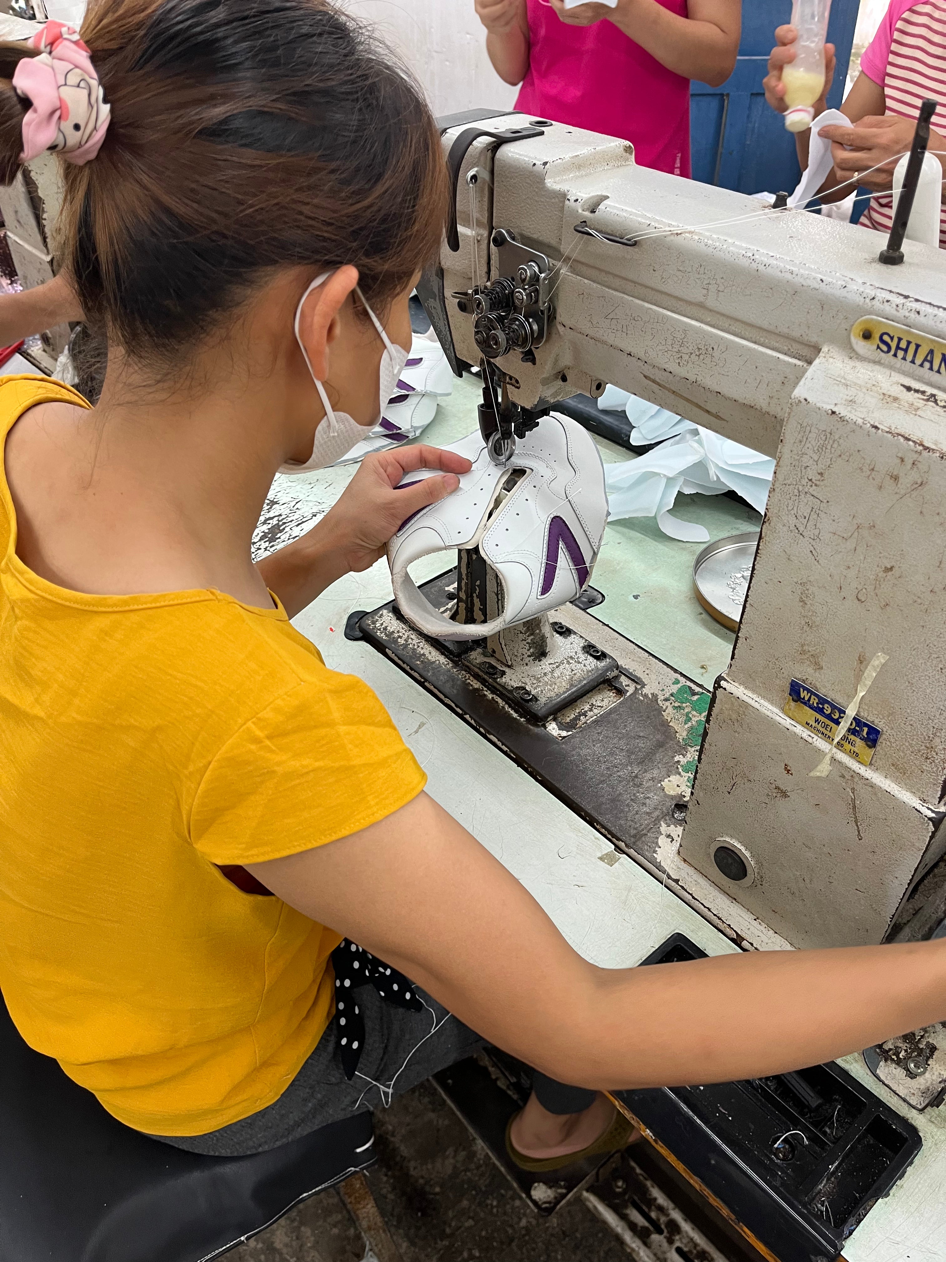 Person operating a sewing machine in a workshop setting