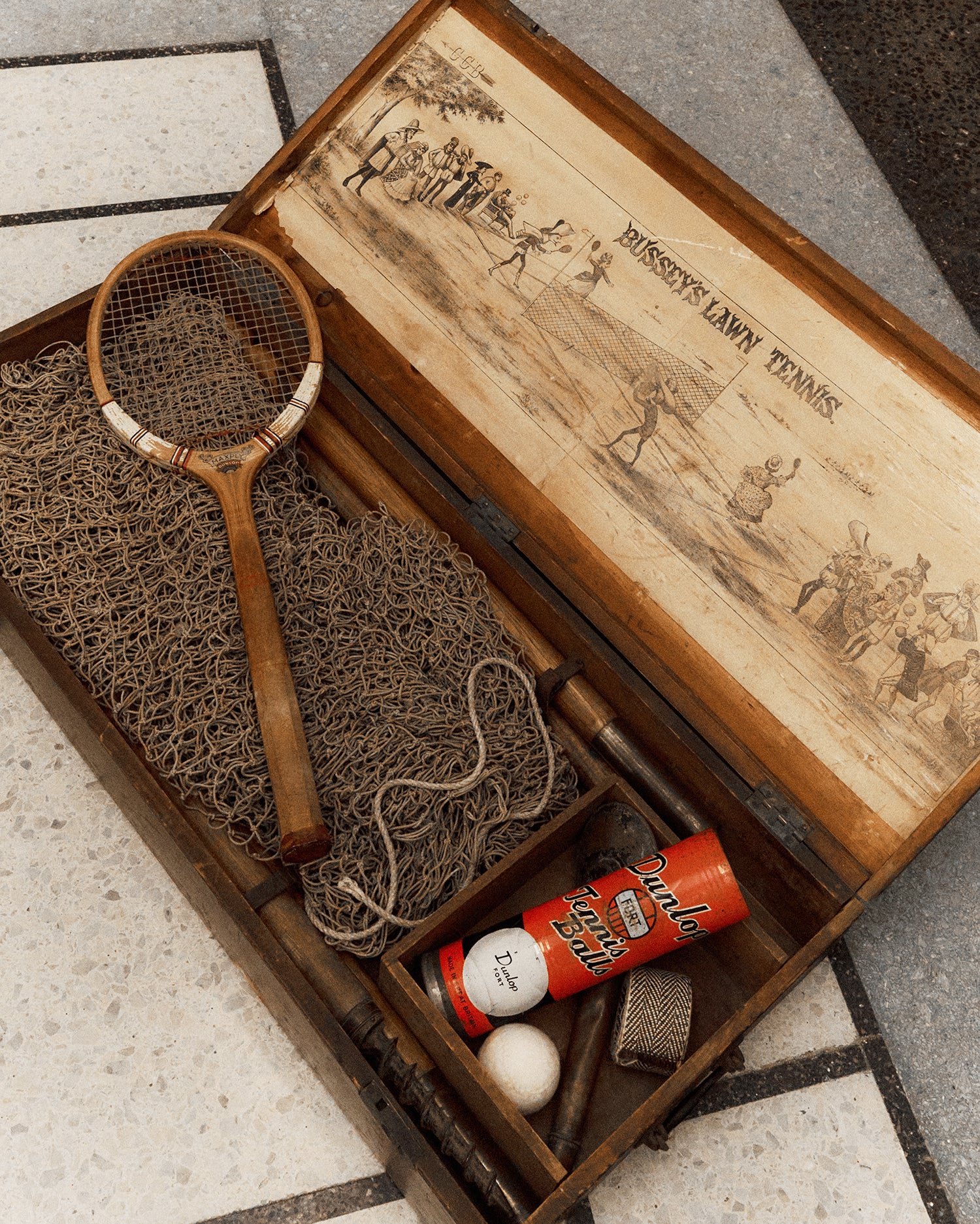 Vintage lawn tennis set with wooden racket, net and Dunlop tennis balls in wooden box.