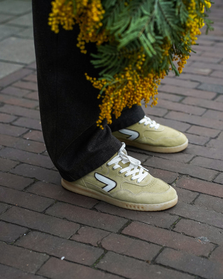Olive suede sneakers on the street with flowers
