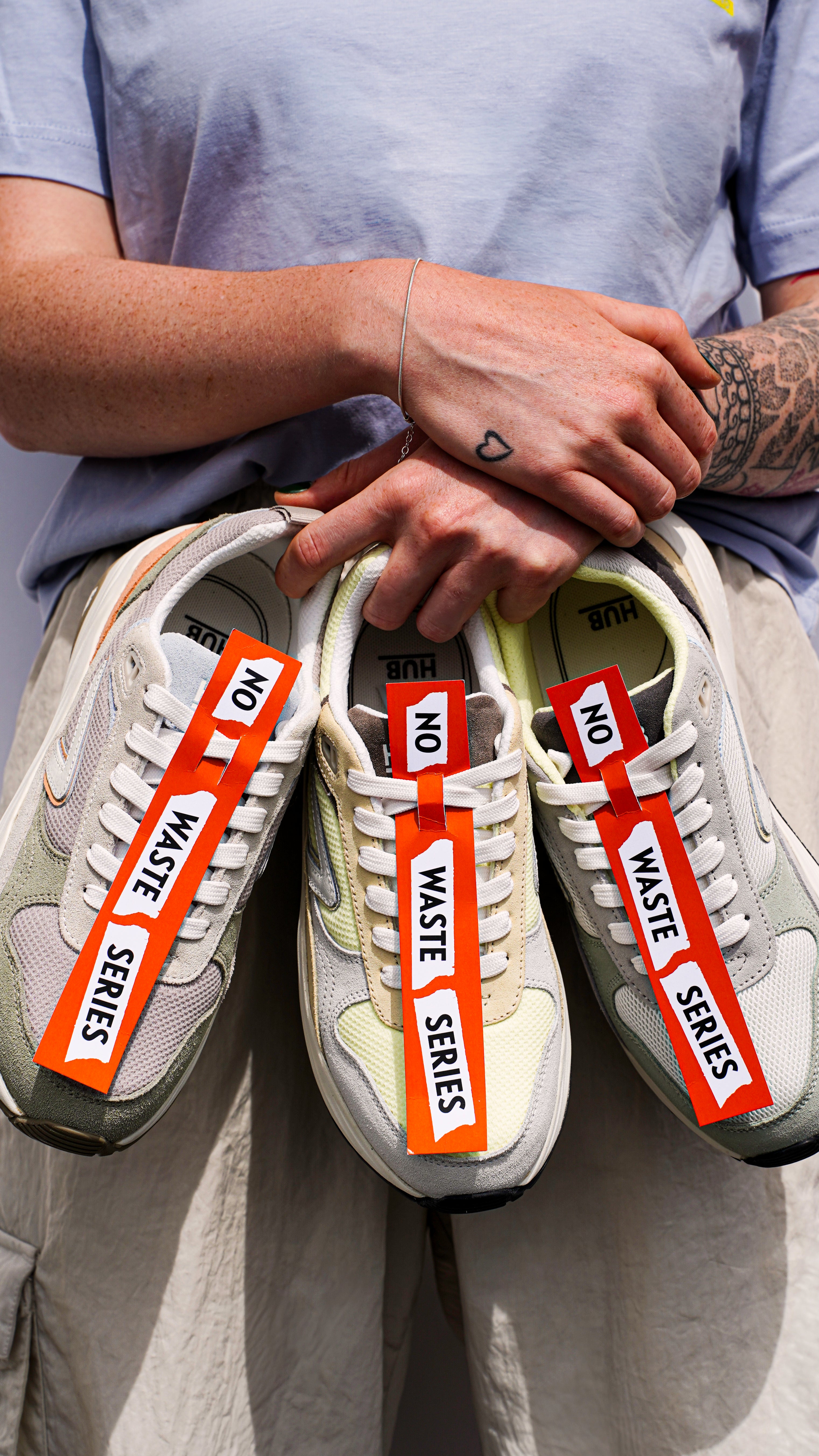 Person holding 3 sneakers with a no waste series label