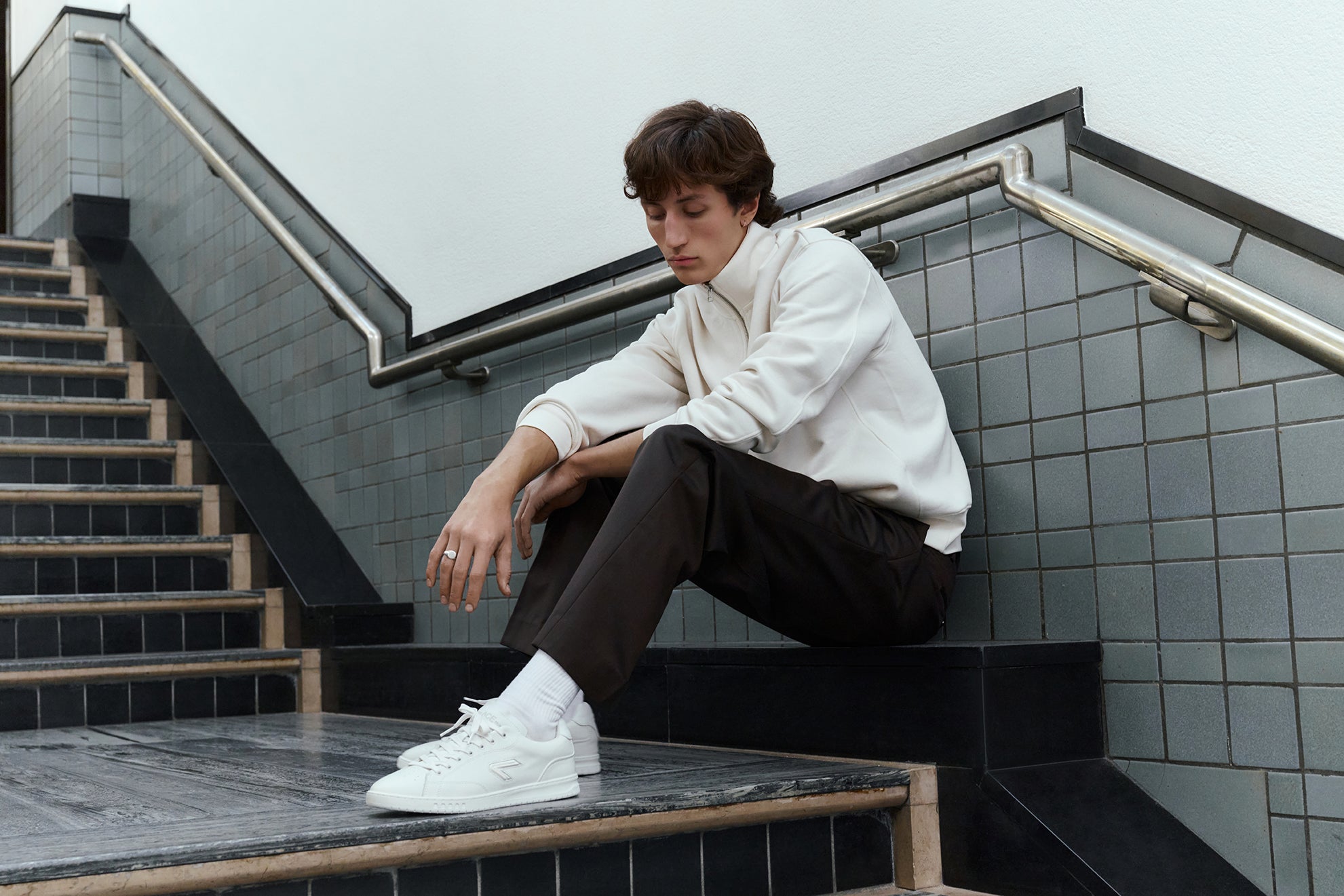 The ACE Hub Shot sneaker in off-white, photographed indoors at an art museum.