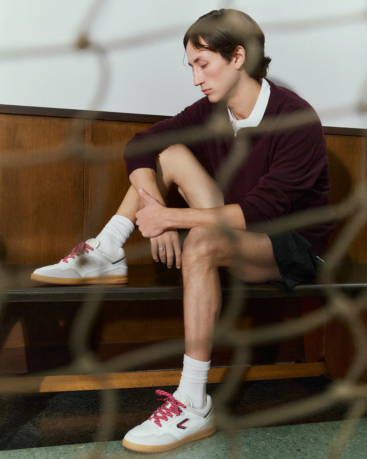 The ACE Hub Sprint sneaker in white and navy with pink laces, photographed indoors at an art museum.