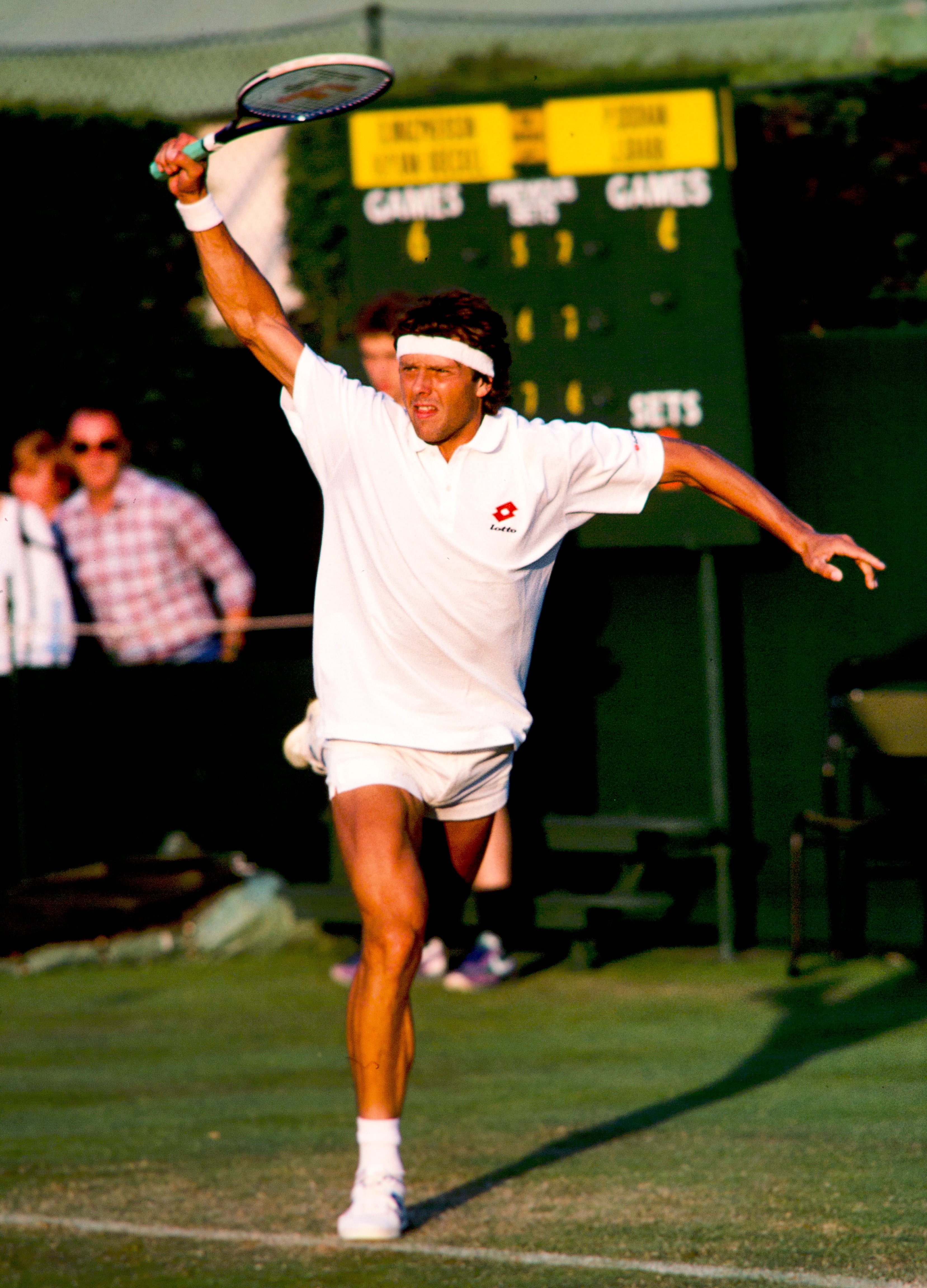 Huub van Boeckel in action on a grass court on Wimbledon with a scoreboard in the background